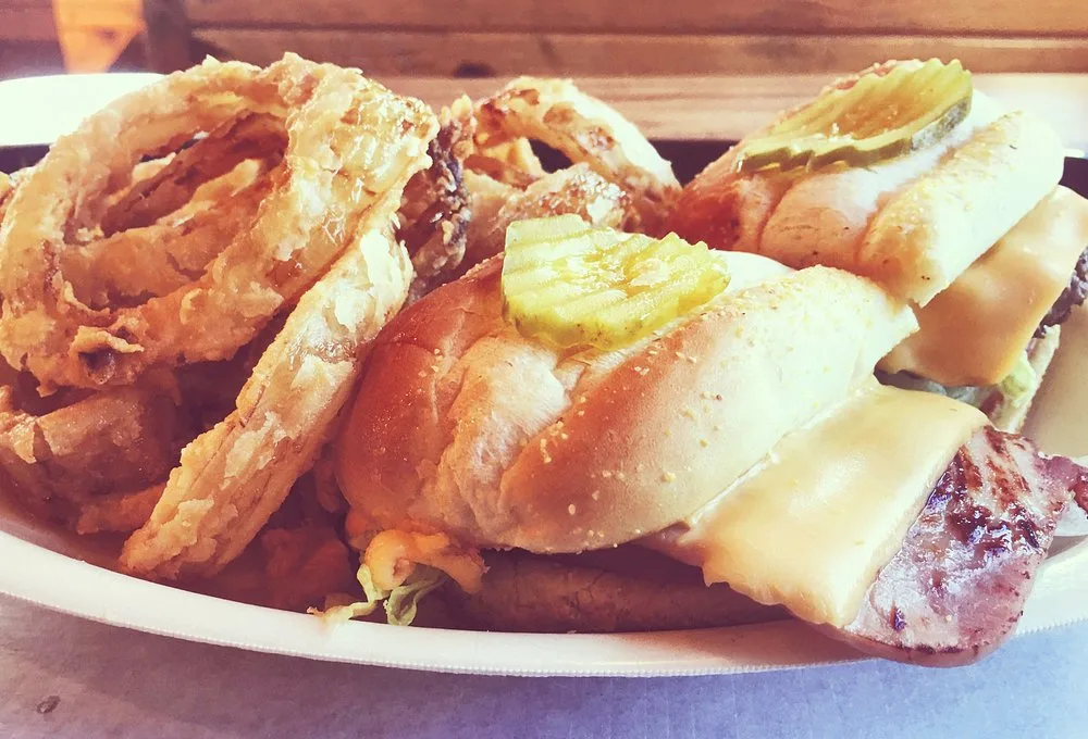 Half and half BBQ sandwich served with onion rings