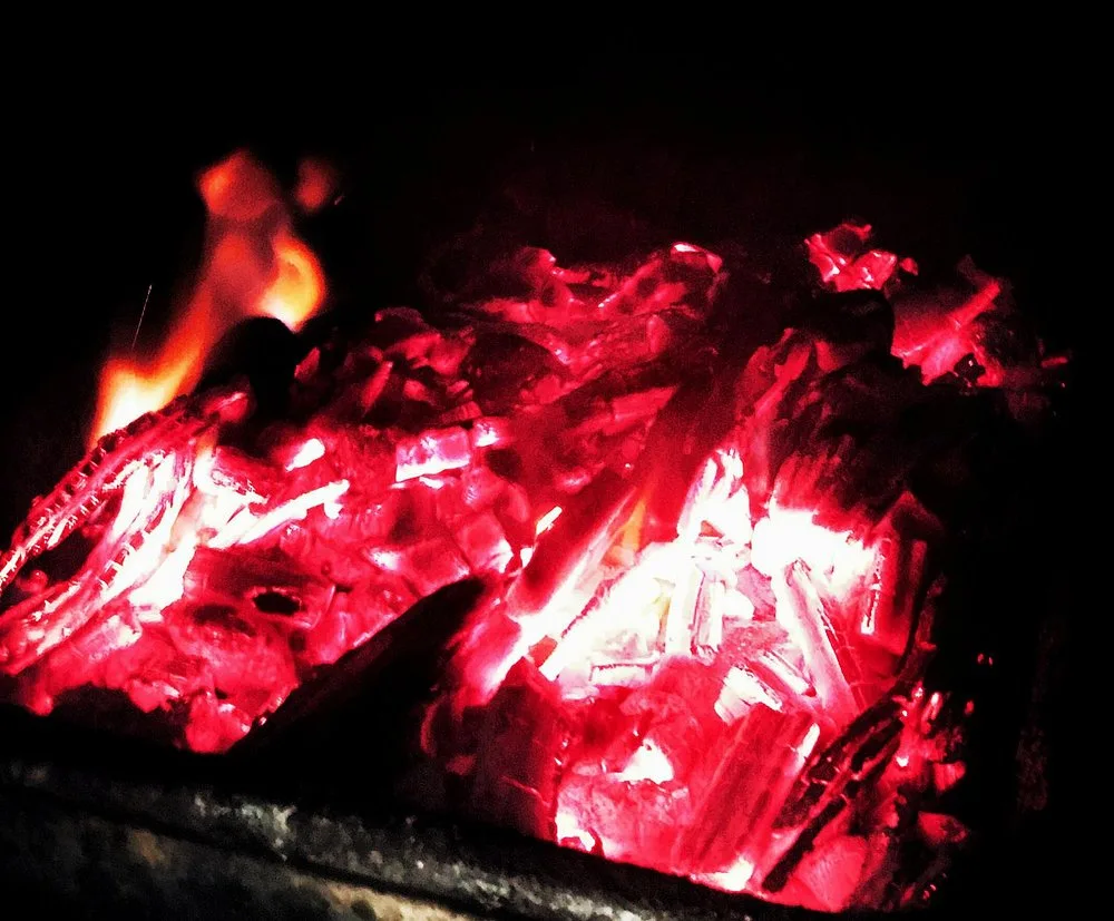 Open flames and glowing hickory logs burning inside the firebox